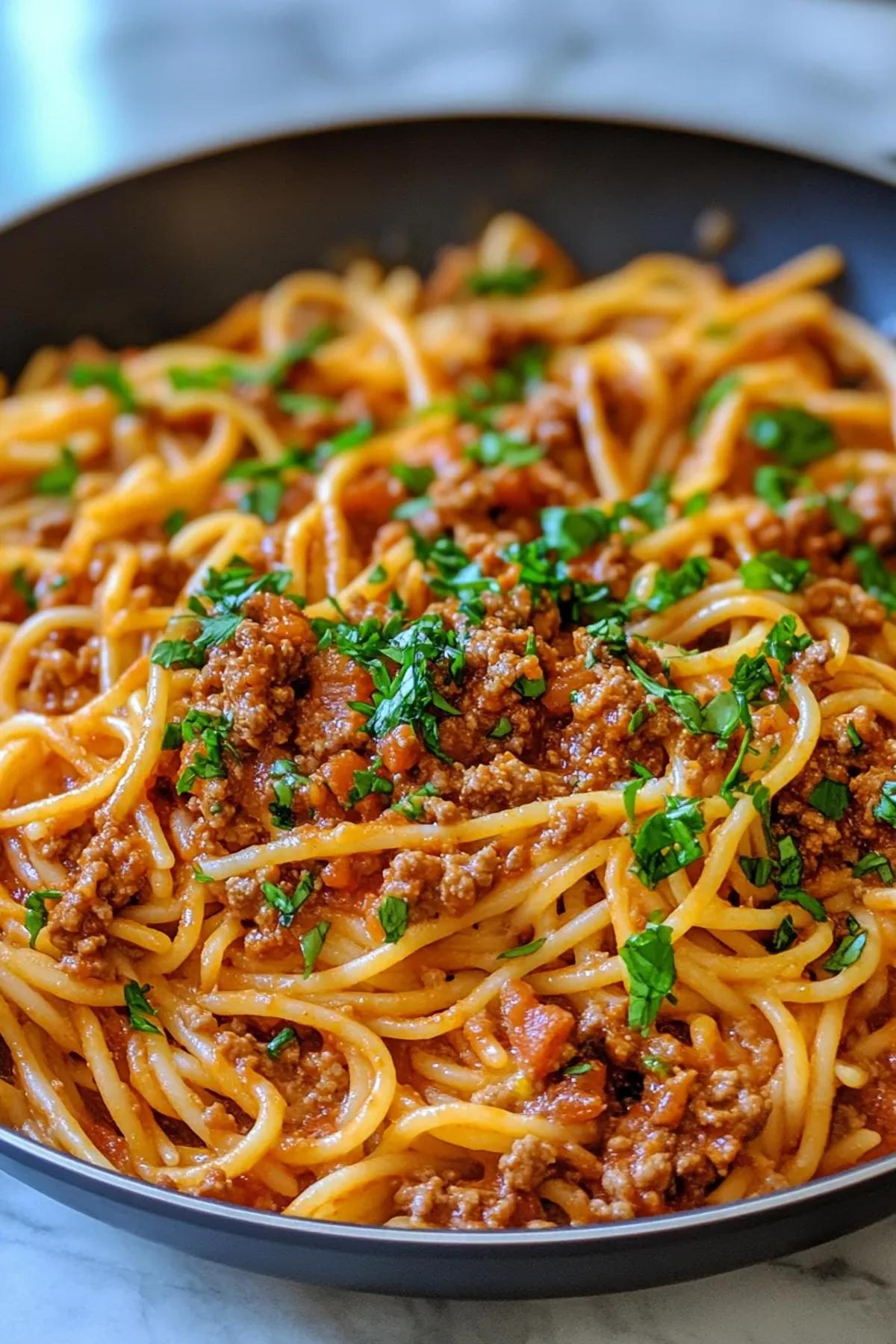 One pan pasta harissa bolognese served in a rustic skillet, glossy tomato‑harissa sauce clinging to al dente spaghetti, topped with fresh basil and a dusting of Parmesan cheese card