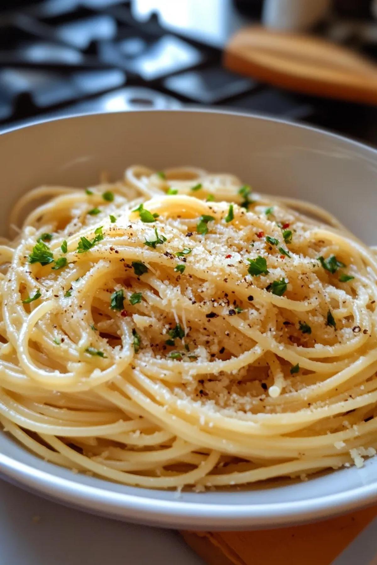 A bowl of garlic butter pasta topped with fresh parsley and grated Parmesan. card